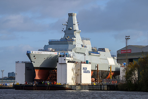 HMS Glasgow, leadship of the new Type 26 / 'City' class global combat frigates for the UK's Royal Navy, is one of a trio of first batch newbuilds out of eight in total to be built by BAE Systems two Glasgow shipyards. AFLOAT adds, last week the 6,000 tonne-newbuild was transferred onto a semi-submersible barge Malin Augustea at the shipyard in Goven from where it was towed downriver to deeper waters on the Clyde at the second shipyard at Scotstoun from where fitting out work is to take place.  