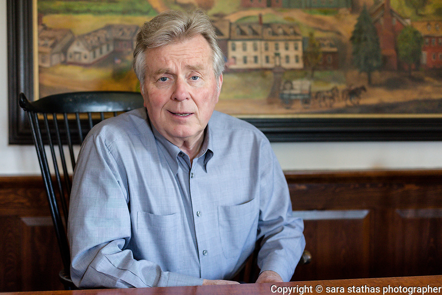 Bob Lang sits in his Delafield, Wisconsin office in front of an original painting of the town of Delafield that he commissioned on Thursday June 1st, 2017.