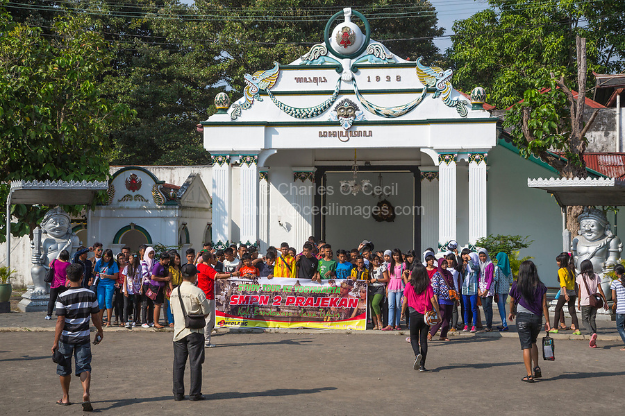 Yogyakarta, Java, Indonesia. Indonesian Students on a School Trip Pose behind a Banner for a Group Picture before entering the Sultan's Palace.