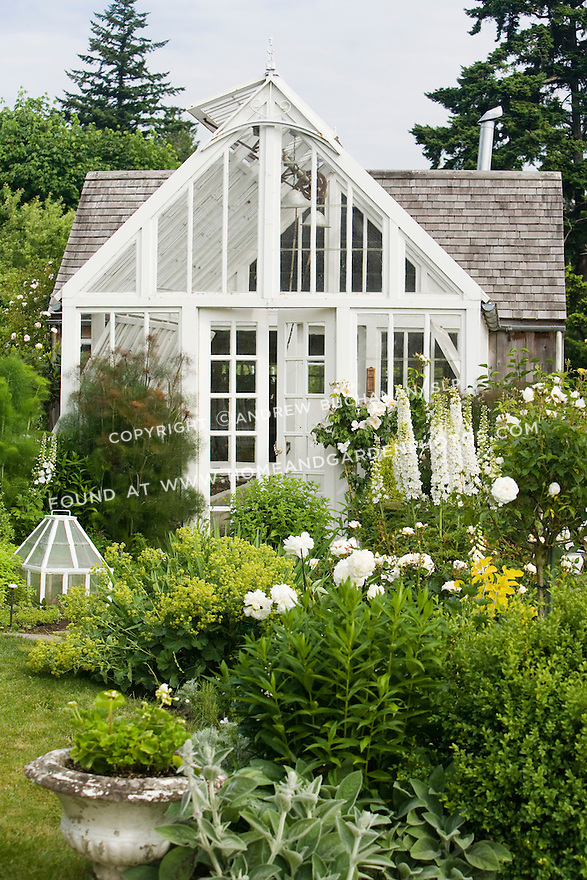 This white-painted greenhouse was salvaged from a local arboretum and restored for use here, and adds to the romantic, cottage garden feel of the Sissinghurst-style white garden behind the late 19th c. farmhouse on this property. The garden also includes white peonies and delphiniums, white roses, and garden flox, among others. Garden design by Toni Christianson, Christianson's Nursery