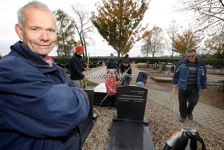 Foto: VidiPhoto<br />
<br />
VALBURG – Sinds anderhalf jaar zwaait diaken Frederik Bunt (blauwe jas) de scepter over het groenonderhoud van de Hervormde begraafplaats Rustoord in Valburg. Dat betekent dat hij ook de jaarlijkse schoonmaakdag daar coördineert en aanwijzingen geeft.