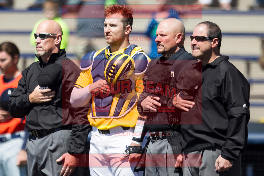 Michigan Wolverines catcher Harrison Wenson (7) stands with umpires Sal Giacomantonio, Mike Martin and Scott Inman during the national anthem before the NCAA baseball game against the Illinois Fighting Illini on April 8, 2017 at Ray Fisher Stadium in Ann Arbor, Michigan. Michigan defeated Illinois 7-0. (Andrew Woolley/Four Seam Images)