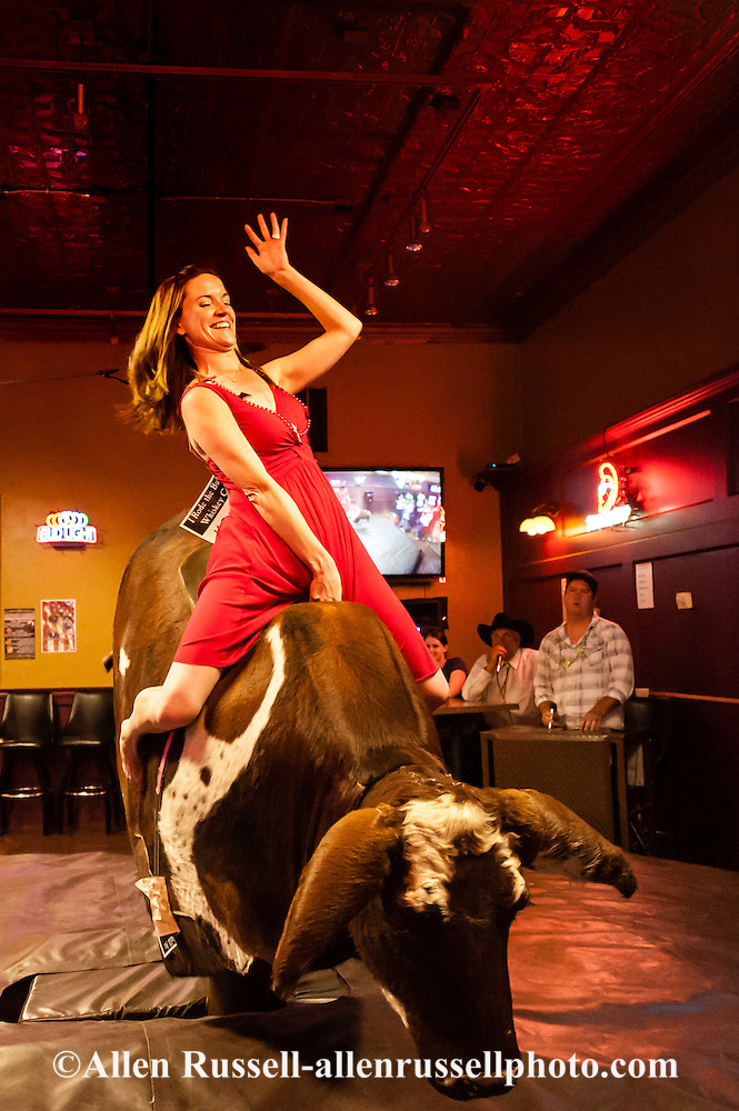 Woman riding mechanical bucking bull at Livingston Roundup Celebration in Montana Allen