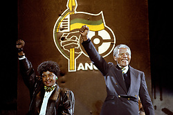 Nelson Mandela, with wife Winnie, gives the famous clench-fist saltue of the African National Congress to tens of thousands of fans who gathered to hear him at a concert in his honour at Wembley Stadium last night.