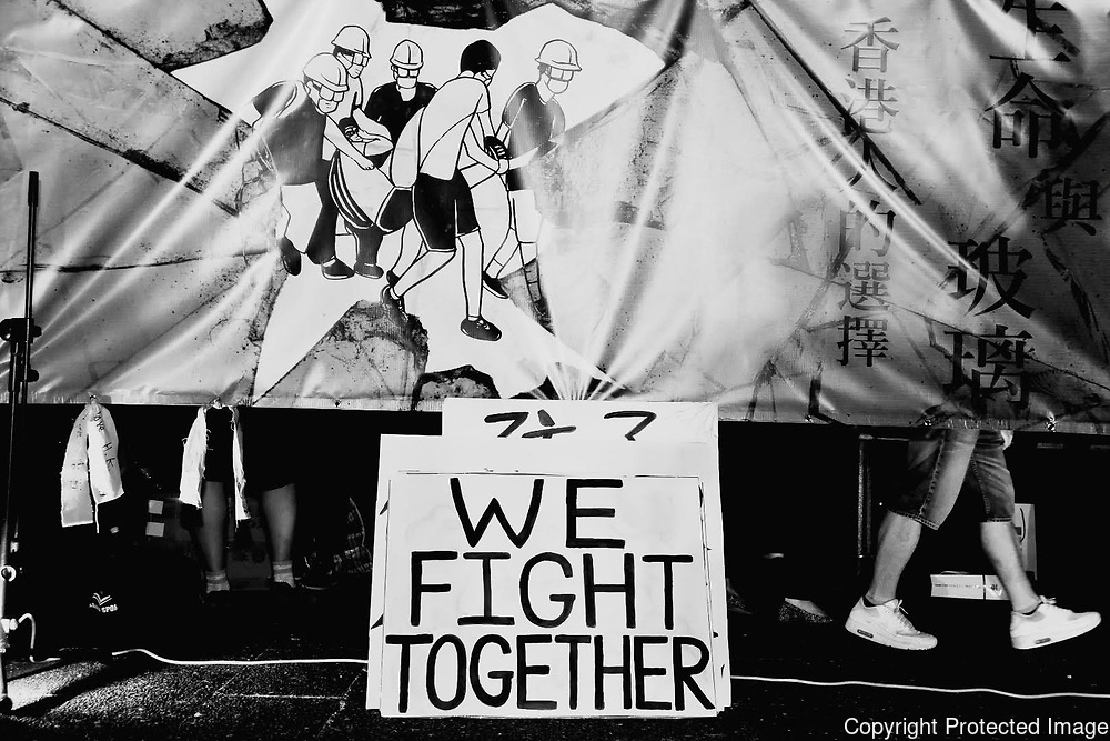 A sign reads, "We Fight Together" amongst protesters' feet during the June protests in Hong Kong. Protesters are opposed to a controversial extradition bill.