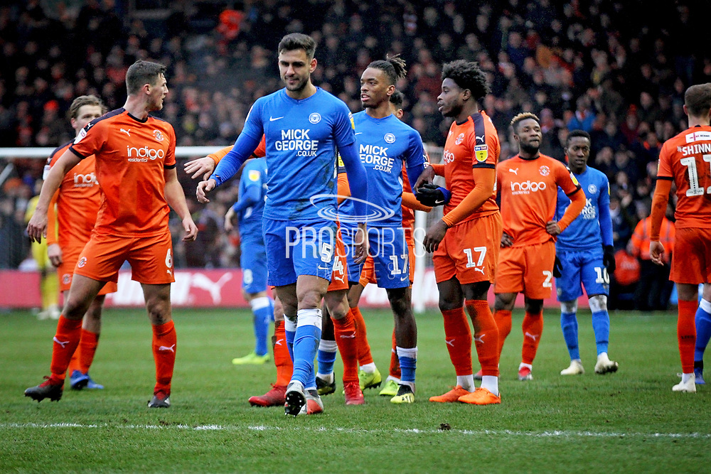 Peterborough Utd defender Ryan Tafazolli (5) walking off after getting sent off while the players argue behind him during the EFL Sky Bet League 1 match between Luton Town and Peterborough United at Kenilworth Road, Luton, England on 19 January 2019.