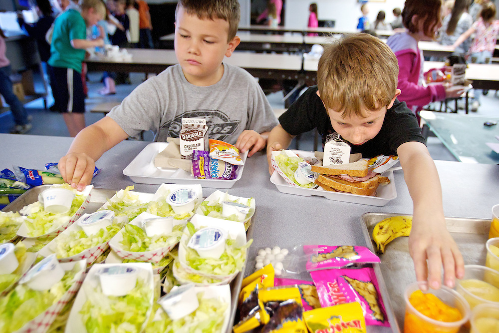 Calvin Longbrake reaches for a cup of oranges as his first-grade classmate Gage Davenport selects a salad for lunch Friday at Mullan Trail Elementary in Post Falls. Mullan Trail was one of 116 Idaho schools awarded grants this year to provide students with a variety of free fresh fruits and vegetables.