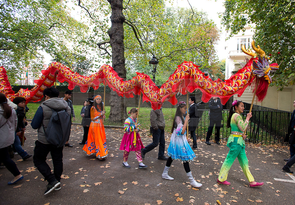 © Licensed to London News Pictures. 20/10/2015. London UK. A group of young Chinese children perform with a dragon on The Mall in London leading to Buckingham palace as Chinese President Xi Jinping starts day one of a four day State Visit to the United Kingdom. Photo credit: Ben Cawthra/LNP