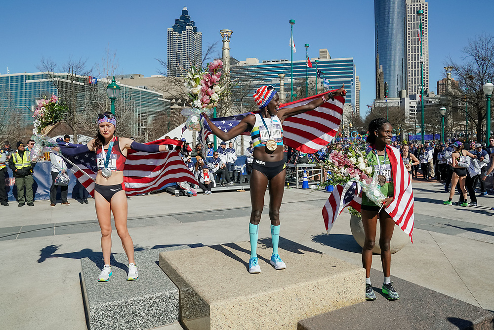 Aliphine Tuliamuk (center), Molly Seidel (left) and Sally Kipyego (right) celebrate winning first, second, and third, respectively, during the 2020 U.S. Olympic marathon trials in Atlanta on Saturday, Feb. 20, 2020. Photo by Kevin D. Liles for The New York Times