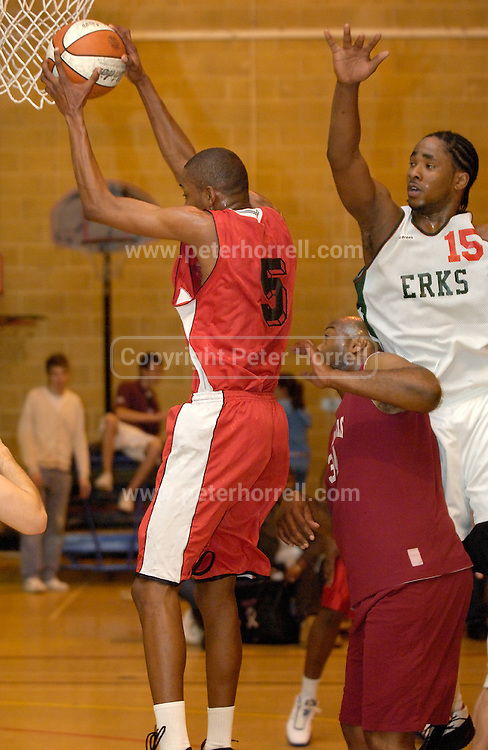 DAGENHAM - MAY 17: Cardinals' Searle (#5) grabs a rebound from Barking and Dagenham Erkenwald's Craig Pringle (#15) during the Essex Metropolitan Basketball League's Play Off final at Sydney Russell School. Cardinals' Tony Peltier is in the middle. Erks won the game 81 - 68. Searle top scored for the Cardinals with 29 points.