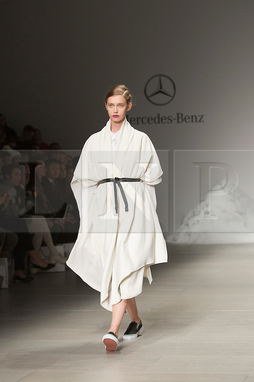 © Licensed to London News Pictures. 18 February 2014, London, England, UK. A model walks the runway at the Mercedes-Benz sponsored SIMONGAO show during London Fashion Week AW14 at the BFC Courtyard Show Space/Somerset House. Photo credit: Bettina Strenske/LNP