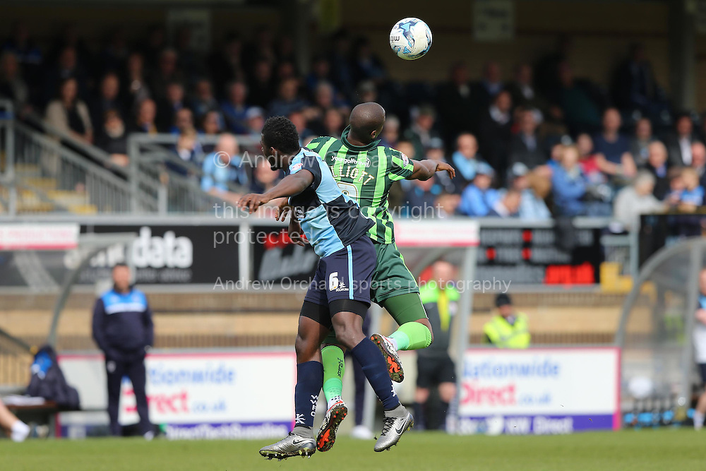 Tom Elliott of AFC Wimbledon jumps over Aaron Pierre of Wycombe Wanderers to head the ball. Skybet football league two match, Wycombe Wanderers v AFC Wimbledon at Adams Park in High Wycombe, Buckinghamshire on Saturday 2nd April 2016.<br />
pic by John Patrick Fletcher, Andrew Orchard sports photography.