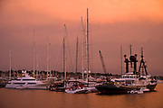 A hazy sunset illuminates Newport harbor and the American Shipyard with an unusually dramatic orange glow.