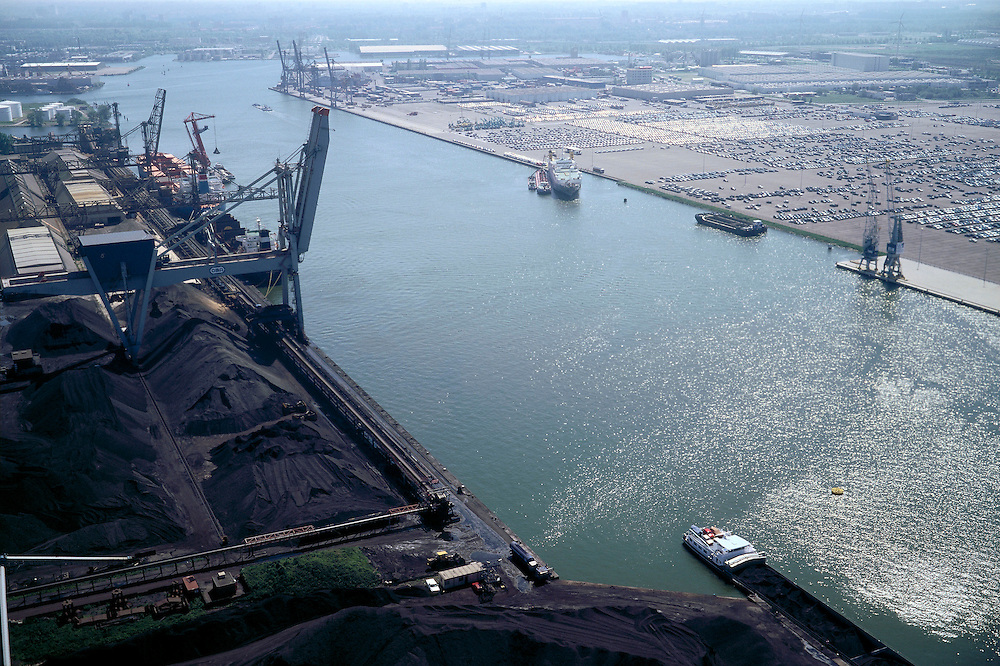 Nederland, Amsterdam, Westhaven, 17/05/2002; Westelijke havengebied - Jan Riebeeckhaven met links OBA BULK TERMINAL AMSTERDAM (kolen, ertsen, mineralen, schroot, agribulk); rechts de terminal van NIssan met terrrein van geimporteerde auoto's; overslag scheepvaart economie bedrijvigheid industrie Noordzeekanaal; Western port - Jan Riebeeck Haven with links OBA BULK TERMINAL AMSTERDAM (coal, ores, minerals, scrap, agricultural bulk); right into the terminal with Nissan of terrrein auoto imported cars, handling shipping industry economics;<br />
luchtfoto (toeslag), aerial photo (additional fee)<br />
foto /photo Siebe Swart