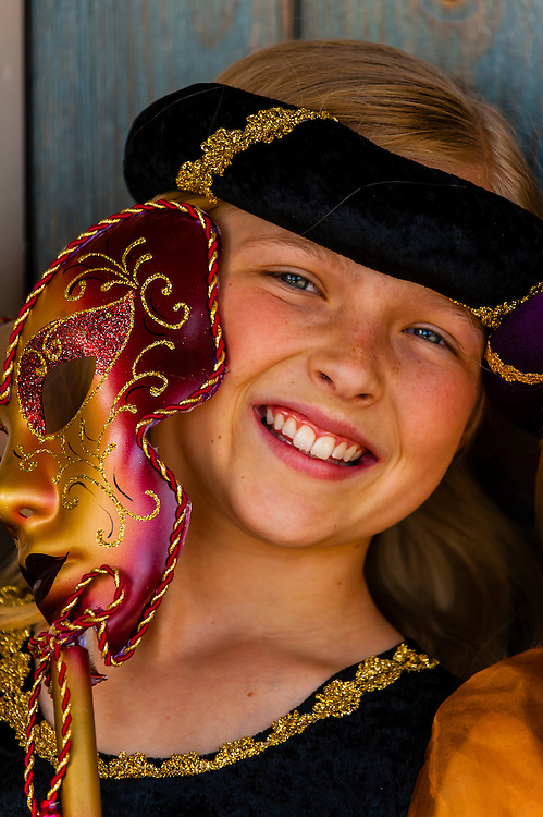 Preteen girl dressed in medieval costume (and holding a Carnival mask), Cedar City, Utah USA. Cedar City is home to the Tony Award-winning Utah Shakespeare Festival.