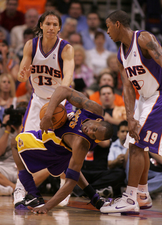 The Lakers' Kobe Bryant gets a hard foul by the Suns' Raja Bell as Steve Nash looks on during the second half of the Lakers 114-97 loss to the Phoenix Suns' in Game 5 of the Western Conference quarterfinals at U.S. Airways Arena in Phoenix, Ariz. Tuesday May 2, 2006.