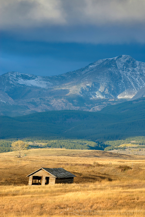 Abandoned homestaed cabin on the Montana plains near the Rocky Mountain Front Ranges of Glacier National Park USA