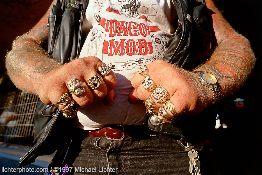 Magoo, Main Street, Sturgis, SD. 1997<br />
<br />
Limited Edition Print from an edition of 20. Photo ©1997 Michael Lichter.<br />
<br />
The Story: Magoo, when not at his shop in Grand Forks, can be found at bike runs all over the country working his tattoo art or just having fun. The two little dogs inside his leather vest have the meanest growl you can imagine. Magoo lives the life.