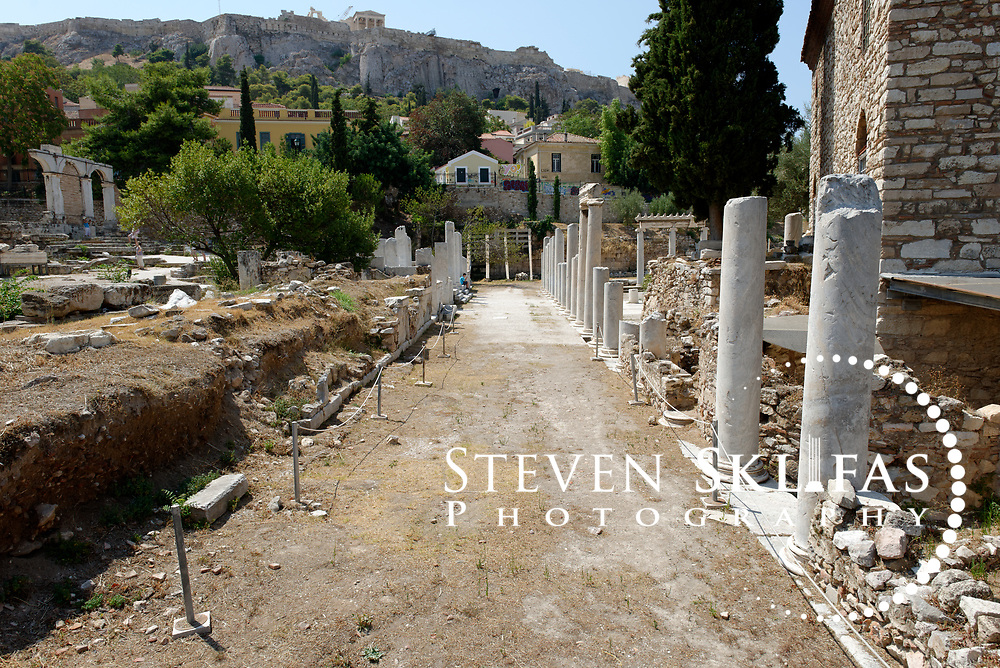 Athens. Greece. Part view of the elegant Ionic peristyle that enclosed the central open space (on right) of the ancient Roman Agora in Athens. On the left is the East Propylon that provided access to the courtyard. Above is the Acropolis. Dating from the 1st century BC, the Roman Agora is about 100 metres to the east of the Ancient Agora and is complex consisting of a large rectangular open courtyard surrounded by stoas, shops and storerooms.