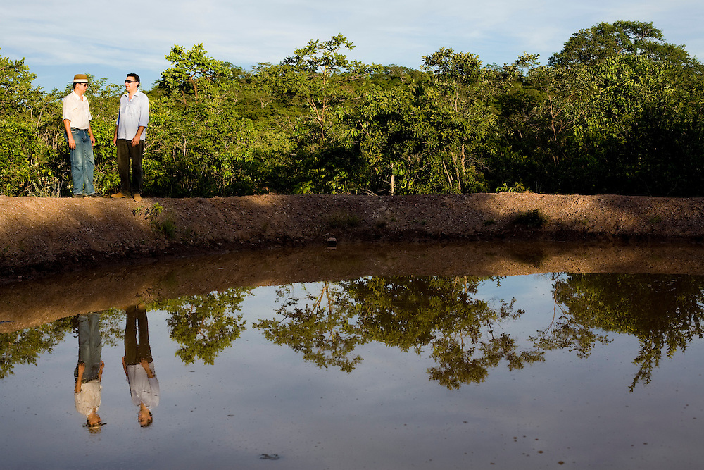 Januaria_MG, Brasil...A fazenda Agroecologica Soma, se intitula uma fazenda produtora de agua. Localiza no municipio de Januaria, a 250 km de Montes Claros, usa a tecnica de Barraginhas ou Bacias de Captacao de Agua de Chuva para recuperar os lencois freaticos e consequentemente os rios da regiao. Em 2005, foram construidas mais de 300 barraginhas na regiao, e acredita-se que o volume de agua dos lencois freaticos cresceu, inclusive com a recuperacao de um rio que corta a propriedade...Na foto, Berilo Prates Maia Filho e Juliano de Souza Maia, proprietarios da fazenda e responsaveis pela aplicacao da tecnologia na regiao, em uma das barraginhas construidas...The Soma Agroecology farm, is called a farm producing water. Located in the city of Januaria, 250 km from Montes Claros, uses the technique rainwater catchment to recover the ground water and consequently the rivers of the region. On 2005, they built 300 dam or rainwater catchment in the region, and it is believed that the volume of water of groundwater has grown, including the recovery of a river in the property...In the photo, Juliano de Souza Maia and Maia Beryl Prates Filho, They are the farm owners, They use the technology in the region, next to the dam...Foto: BRUNO MAGALHAES / NITRO