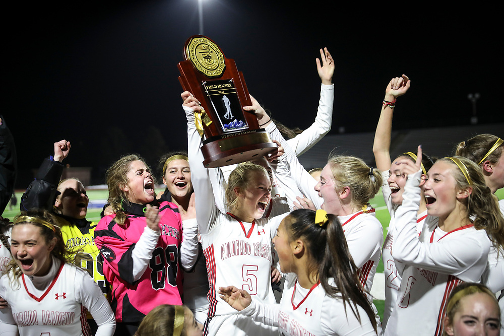 SHOT 11/5/19 8:25:00 PM - Colorado Academy field hockey teammates celebrate as they're presented the 2019 CHSAA State Field Hockey Tournament Championship trophy at All-City Stadium Tuesday evening. Colorado Academy won the game 2-1 over Regis Jesuit to earn the state title. (Photo by Marc Piscotty / © 2019)
