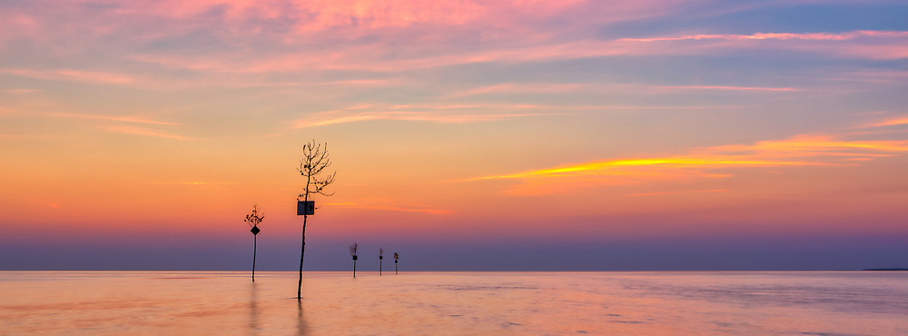 Cape Cod sunsets never disappoint. I caught the beautiful days end light at Rock Harbor where the iconic clam trees lining up the entryway into Rock Harbor from Cape Cod Bay which make for great compositional features. Rock Harbor in Orleans is one of the best spots to catch the end of day along the many beaches of the Cape Cod BayRock Harbor is easily accessed off Route 6 at the rotary in Orleans, Cape Cod and provides beautiful sunset and seaside photography opportunities if one combines a lovely beach walk with panorama seascape photography. It is a popular destination for locals and tourists alike to view a beautiful Cape Cod Bay sunset.<br />
<br />
Cape Cod Bay sunset panorama photography images are available as museum quality photography prints, canvas prints, acrylic prints or metal prints. Fine art prints may be framed and matted to the individual liking and decorating needs:<br />
<br />
https://juergen-roth.pixels.com/featured/cape-cod-rock-harbor-clam-trees-sunset-panorama-juergen-roth.html<br />
<br />
Good light and happy photo making!<br />
<br />
Juergen