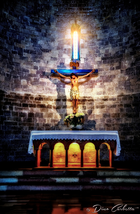 "Crucifixion above the altar of the Church of Santa Maria Maggiore in Assisi"...<br />
<br />
The Church of Santa Maria Maggiore in Assisi is located outside the first city walls, in Piazza del Vescovado. It was the heart of the medieval bishop's citadel and center of religious power until the 11th century when it gave the title of the Cathedral to San Rufino. According to tradition, the first Cathedral of Assisi was built on this site close to the Roman city walls in the 4th century. The crypt under the apse of the present church, which is the oldest surviving part of the structure, seems to date to the 9th or 10th century. St. Francis was baptized in the temple. The interior has a basilica plan with three naves, separated by pillars. In the early Middle Ages, it was an episcopal residence. In 1035, at the time of Bishop Ugone, the title of Cathedral was transferred from Santa Maria Maggiore to the church of San Rufino, where the relics of the patron saint were kept. San Francesco was a guest of Bishop Guido I several times in the adjacent Palazzo Vescovile, in front of which he stripped off his clothes, nurturing a special bond with the church of Santa Maria Maggiore. A stone outside the apse bears witness to works carried out at the time of Francis and Bishop Guido in the year 1216. I found the ancient church to be uncomplicated, yet comforting and reverent. The primitive and recently discovered catacombs below, reveal their age and status throughout history.