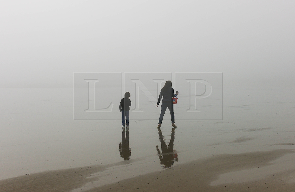 © Licensed to London News Pictures. <br />
08/05/2016. <br />
Saltburn by the Sea, UK. <br />
<br />
A mother and son walk across wet sand as heavy fog shrouds the coastline at Saltburn by the Sea in North Yorkshire as much of the country enjoys the hottest temperatures of the year so far.<br />
<br />
Photo credit: Ian Forsyth/LNP