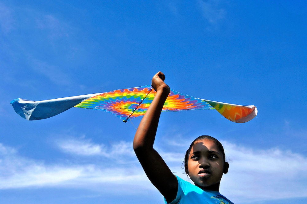 Why won't mine fly?" Tynesha Green, 9, asks the skies over the Douglass Park ball field, already crowded with colorful kites.<br />
<br />
Tynesha and her sister Kanisha, 8, have come with their mentors, Amanda Koellmer and Lauren Smith, volunteers with Big Brothers Big Sisters. They have one mission: to get airborne.<br />
<br />
The first few kites are failures. Toy Story, Elmo and inflatable Winnie the Pooh all crash and burn. Tynesha jogs across the soggy field, the cuffs of her jeans muddy, her arm outstretched to release the string. Each time the kites return to earth, her spirits deflate a little more.<br />
<br />
After a consultation with a local kite-flying expert, Tynesha revives her quest with another new kite. She names it "Tie-Dye" for its spiral of rainbow colors. "Tie-Dye, you're going to be the best flier ever," Tynesha says.<br />
<br />
Tynesha runs across the outfield, dodging younger children and jumping over kite strings. From the outfield to the infield, from the infield to the basketball courts, Tynesha is determined to fly, but the winds are not cooperating.<br />
<br />
"You guys hungry? Ready to leave?" Amanda asks. The girls are discouraged. They look at each other. "I want to try one more time," Tynesha says.<br />
<br />
With the wind at her back she catches a breeze, and "Tie-Dye" lifts into the Saturday afternoon sky. Tynesha jumps. She screams. She's flying.<br />
<br />
After a short minute, "Tie-Dye" comes back to earth, but the girls are energized by their victory. They get a second wind, a third, a fourth and then the inevitable. "Tie-Dye" is caught high in the branches of a tree. As they try to retrieve it, the string snaps and the colorful kite becomes impossible to reach.<br />
<br />
Kanisha collects her own kite. Empty-handed, Tynesha follows Lauren and Amanda back to the parking lot, shedding tears for "Tie-Dye," now trapped in flight forever.