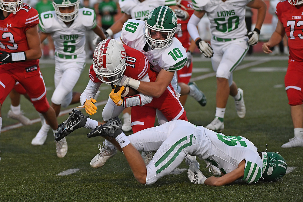 Taite Beachy #10 of the Moon Tigers is wrapped up for a tackle by Ryan Kovatch #10 of the South Fayette Lions in the first half during the game at Tiger Stadium on October 1, 2021 in Moon Township, Pennsylvania.