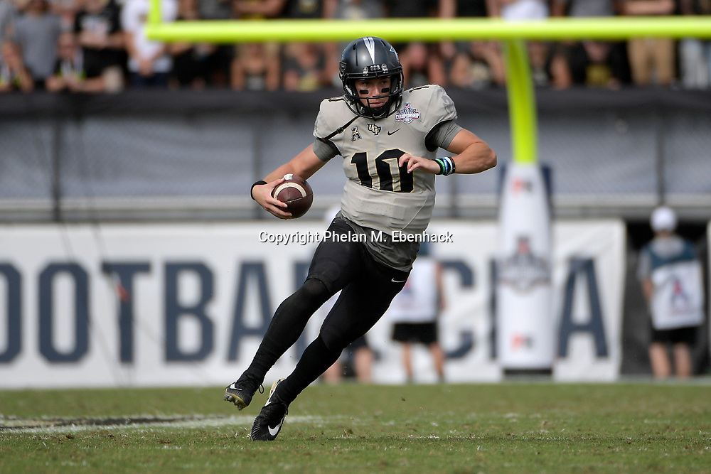 Central Florida quarterback McKenzie Milton (10) scrambles for yardage during the first half of the American Athletic Conference championship NCAA college football game against Memphis Saturday, Dec. 2, 2017, in Orlando, Fla. (Photo by Phelan M. Ebenhack)
