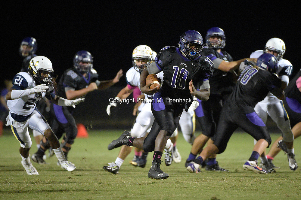Timber Creek running back Jacques Patrick (10) rushes past University defensive back Mykal Woulard (21) for one of his five touchdowns of the first half of a high school football game in Orlando, Fla., Friday, Oct. 17, 2014. (Photo by Phelan M. Ebenhack)